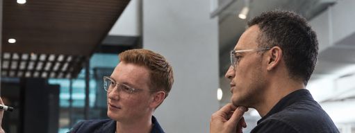 Двое из команды Redround обсуждают схему у доски